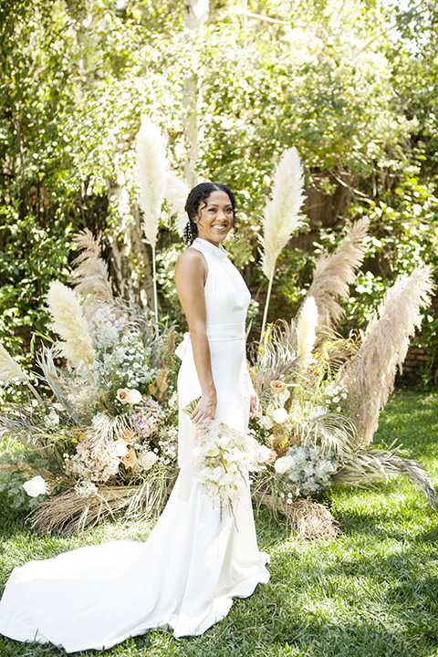  backyard bohemian elopements with the bride in a high neckline gown and the groom in a caramel suit -bride