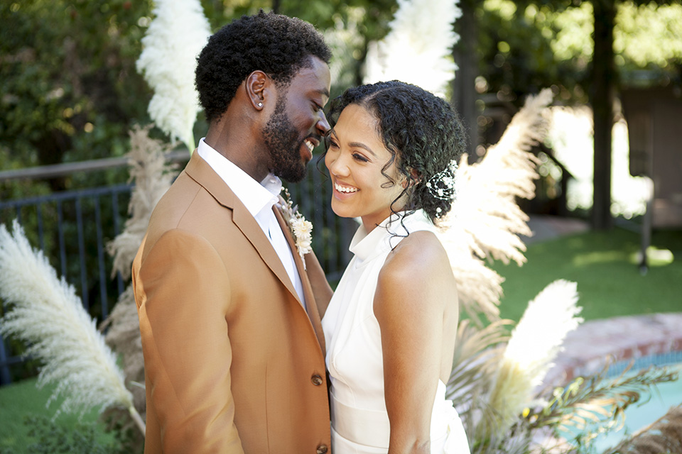  backyard bohemian elopements with the bride in a high neckline gown and the groom in a caramel suit -table 