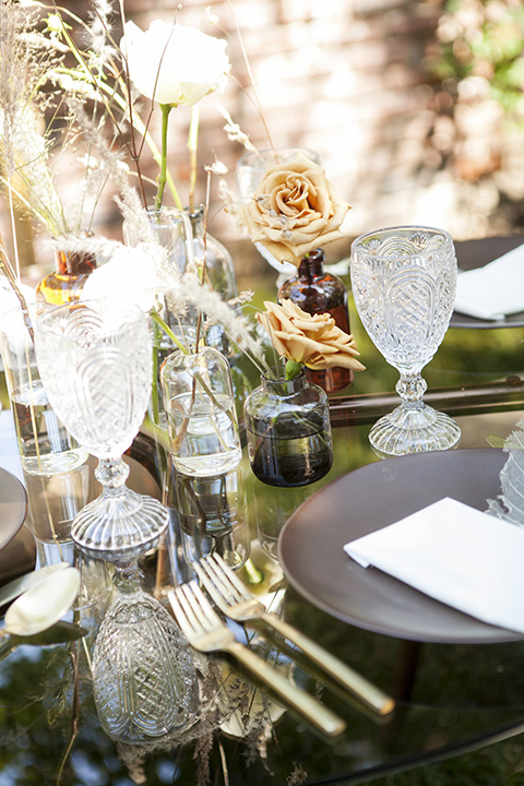  backyard bohemian elopements with the bride in a high neckline gown and the groom in a caramel suit -table decor