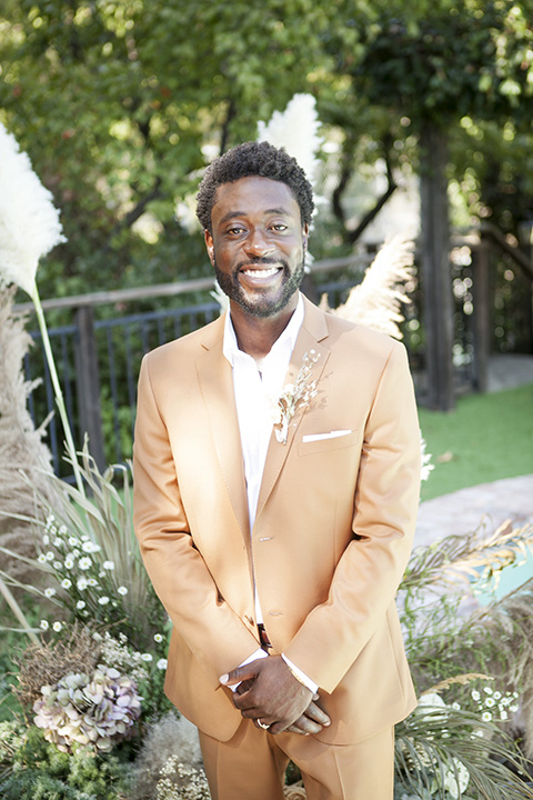  backyard bohemian elopements with the bride in a high neckline gown and the groom in a caramel suit -groom 