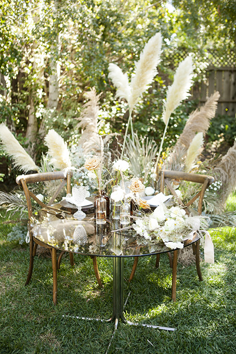  backyard bohemian elopements with the bride in a high neckline gown and the groom in a caramel suit -table 