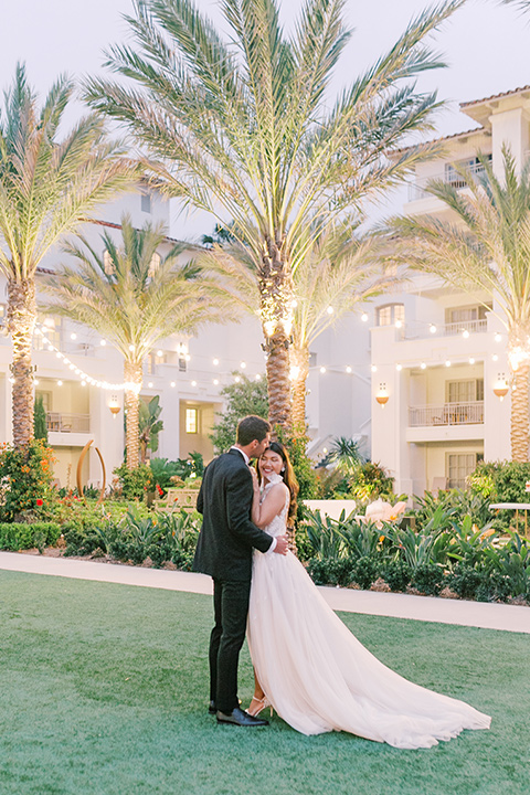  black tie wedding with a sting light reception and the bride in a modern ballgown and the groom in a black tuxedo 