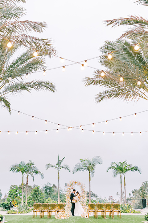  black tie wedding with a sting light reception and the bride in a modern ballgown and the groom in a black tuxedo 