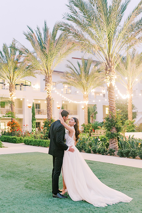  black tie wedding with a sting light reception and the bride in a modern ballgown and the groom in a black tuxedo 