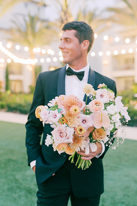  black tie wedding with a sting light reception and the bride in a modern ballgown and the groom in a black tuxedo 