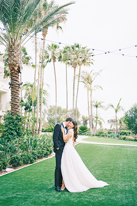  black tie wedding with a sting light reception and the bride in a modern ballgown and the groom in a black tuxedo 