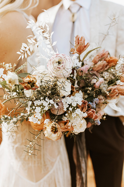  bohemian elopement in antelope canyon – couple close with flowers 