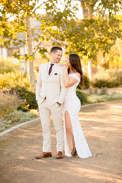  engagement photos with the groom in a tan suit and the bride in a white suit 