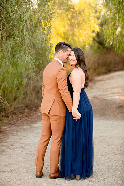  engagement photos with the groom in a tan suit and the bride in a white suit 