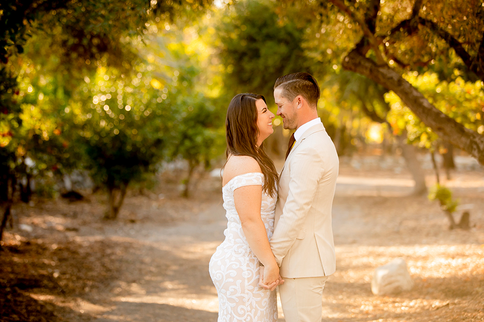  engagement photos with the groom in a tan suit and the bride in a white suit 