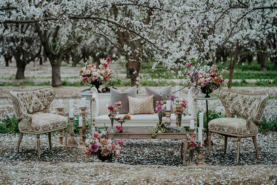  bride in a pastel pink and blue gown and the groom in a rose pink suit and gold bow tie 