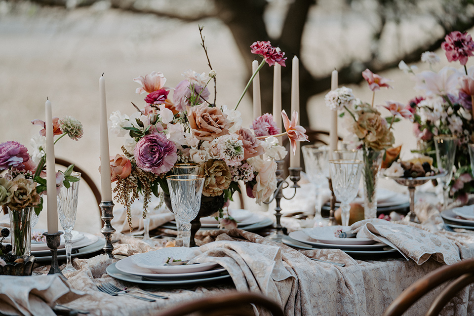  bride in a pastel pink and blue gown and the groom in a rose pink suit and gold bow tie 