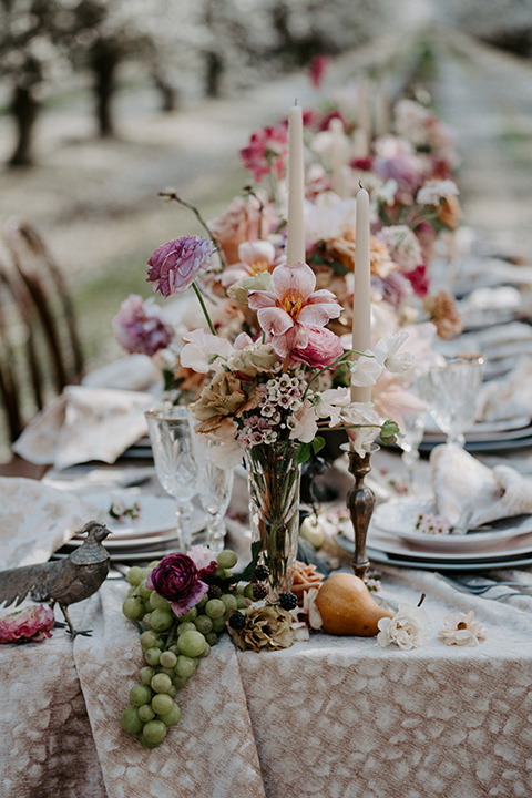  bride in a pastel pink and blue gown and the groom in a rose pink suit and gold bow tie 