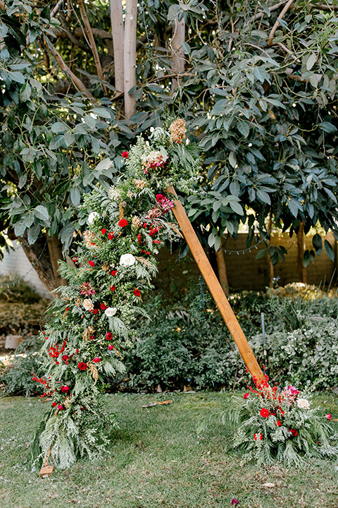  Christmas styled shoot with a wooden arch and red and green florals 