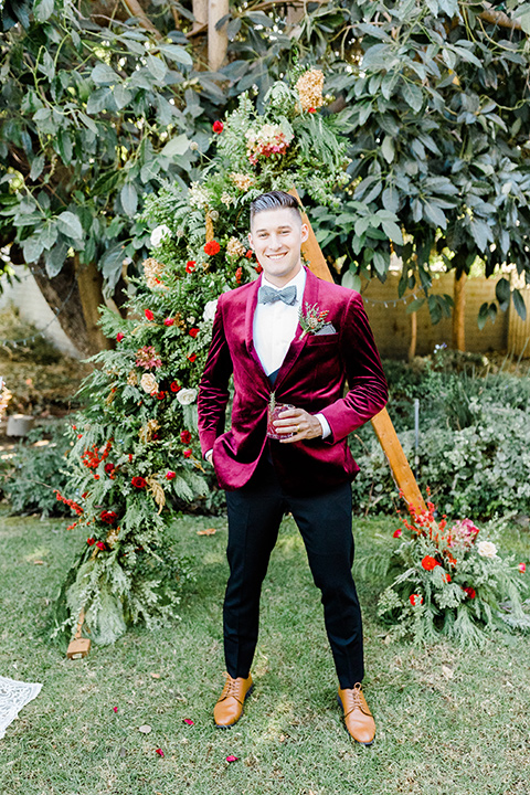  Christmas styled shoot with the groom in a burgundy velvet tuxedo and black pants 