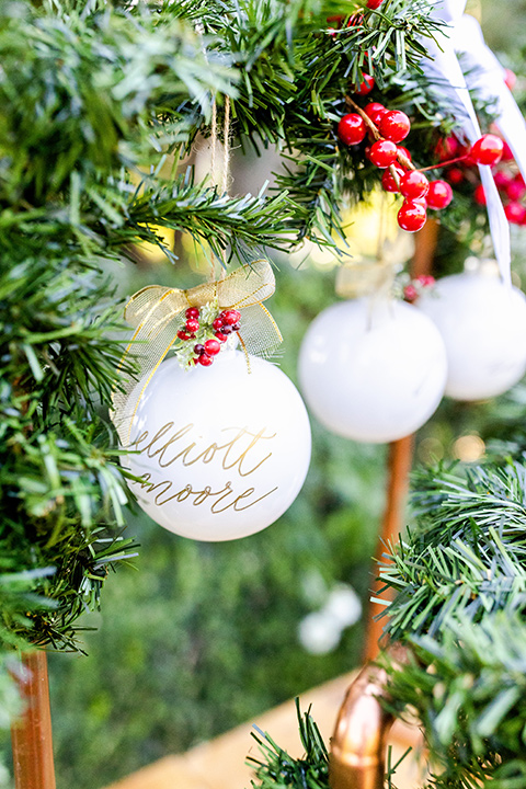  Christmas styled shoot with the groom in a burgundy velvet tuxedo and black pants  and the bride in a white long formfitting gown and long sleeves