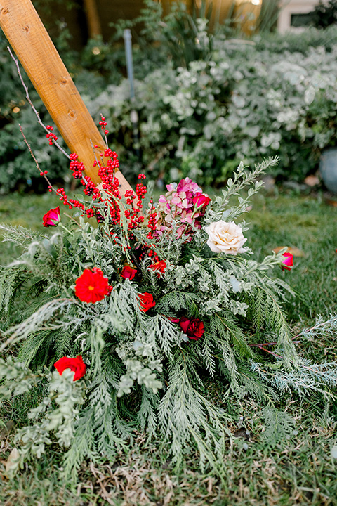  Christmas styled shoot with a wooden arch and red and green florals 