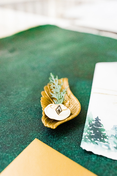  Christmas styled shoot with the groom in a burgundy velvet tuxedo and black pants  and the bride in a white long formfitting gown and long sleeves 