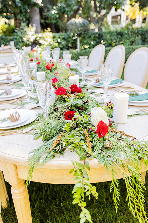  Christmas styled shoot with the groom in a burgundy velvet tuxedo and black pants  and the bride in a white long formfitting gown and long sleeves