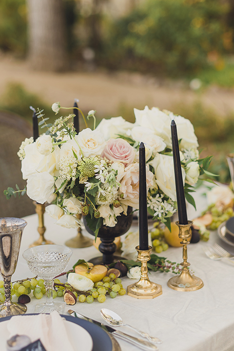  bride in a black lace gown and the groom in a green velvet tuxedo with a black bow tie and shoes 