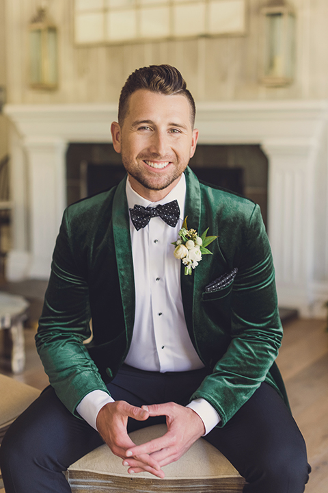  bride in a black lace gown and the groom in a green velvet tuxedo with a black bow tie and shoes 