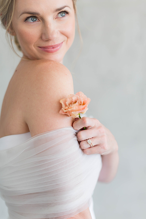  a modern black tie style wedding with the bride in a formfitting gown with a tulle off the shoulder 2 piece wedding gown and the groom in a black tuxedo 