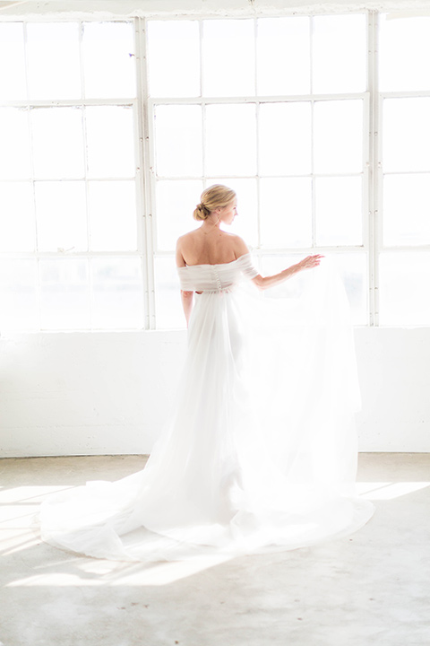  a modern black tie style wedding with the bride in a formfitting gown with a tulle off the shoulder 2 piece wedding gown and the groom in a black tuxedo