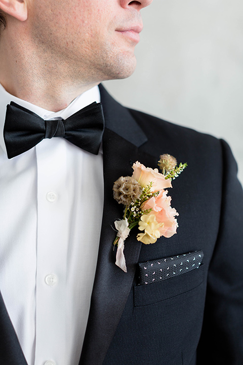  a modern black tie style wedding with the bride in a formfitting gown with a tulle off the shoulder 2 piece wedding gown and the groom in a black tuxedo 