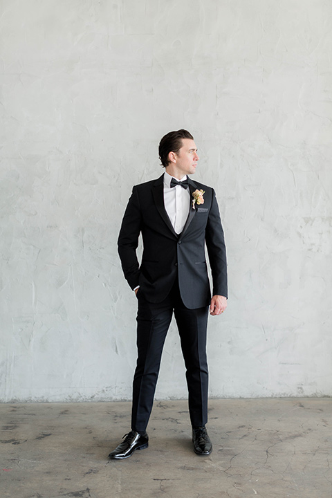  a modern black tie style wedding with the bride in a formfitting gown with a tulle off the shoulder 2 piece wedding gown and the groom in a black tuxedo