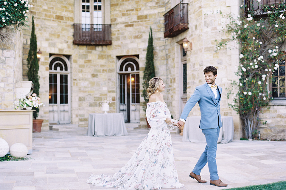  estate vineyard wedding with the bride in a floral gown and the groom in a light blue suit 