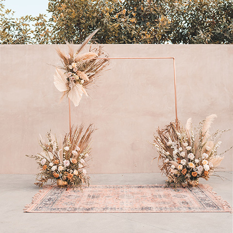  wedding ceremony arch with dried flowers on a wood or copper base 