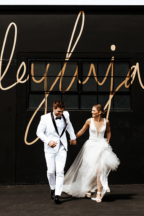  alleylujah neutral wedding – bride in a modern white gown and the groom in a white shawl lapel tuxedo 