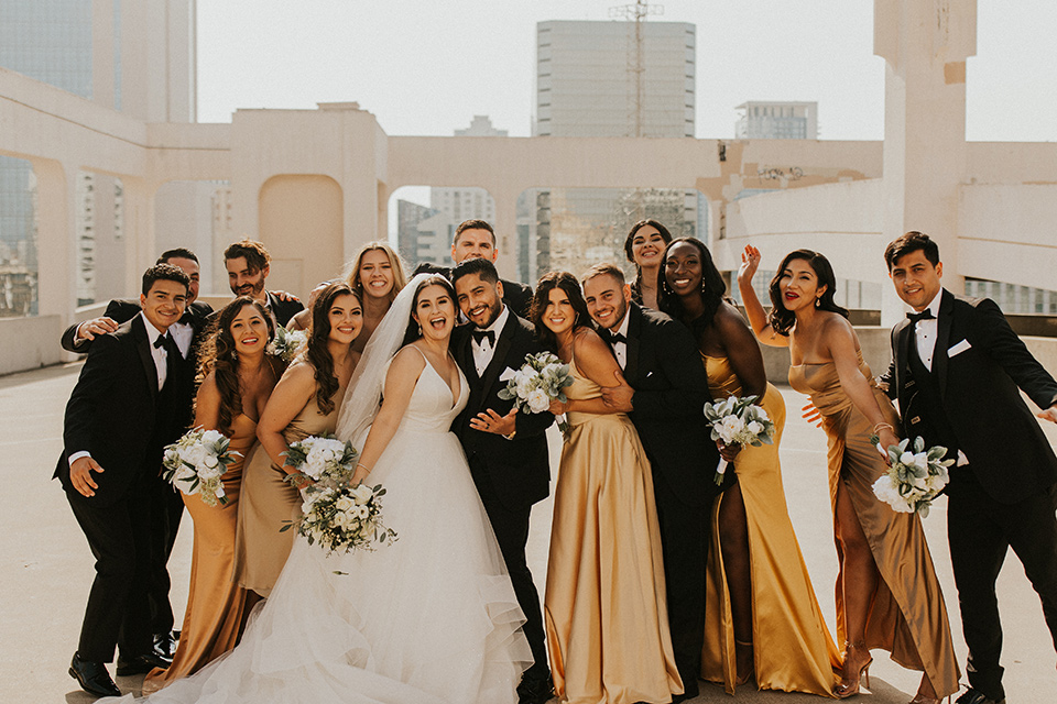  industrial wedding at the pannikin building in san diego with gold bridesmaids gowns and black tuxedos for the groom and groomsmen 