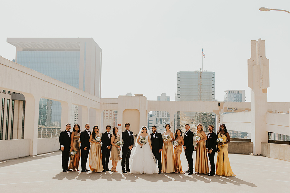  industrial wedding at the pannikin building in san diego with gold bridesmaids gowns and black tuxedos for the groom and groomsmen 