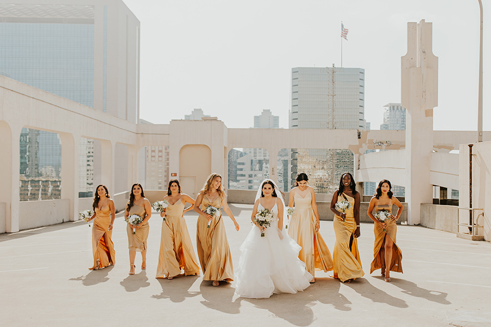  industrial wedding at the pannikin building in san diego with gold bridesmaids gowns and black tuxedos for the groom and groomsmen 