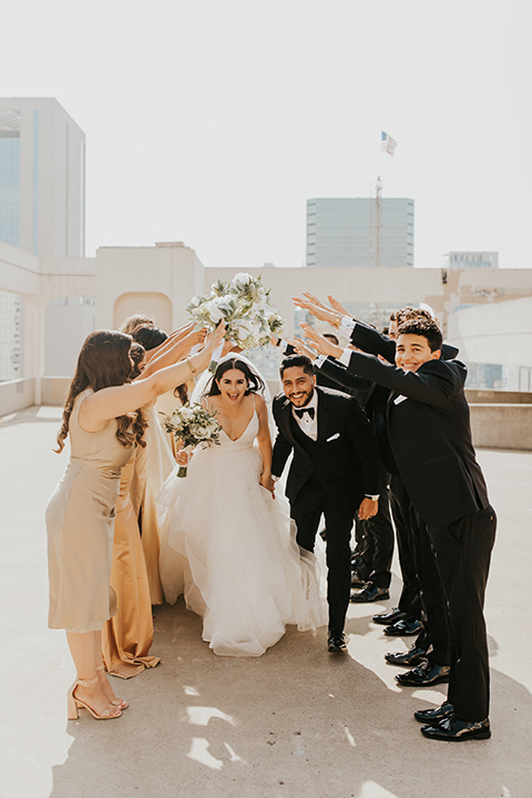  industrial wedding at the pannikin building in san diego with gold bridesmaids gowns and black tuxedos for the groom and groomsmen 