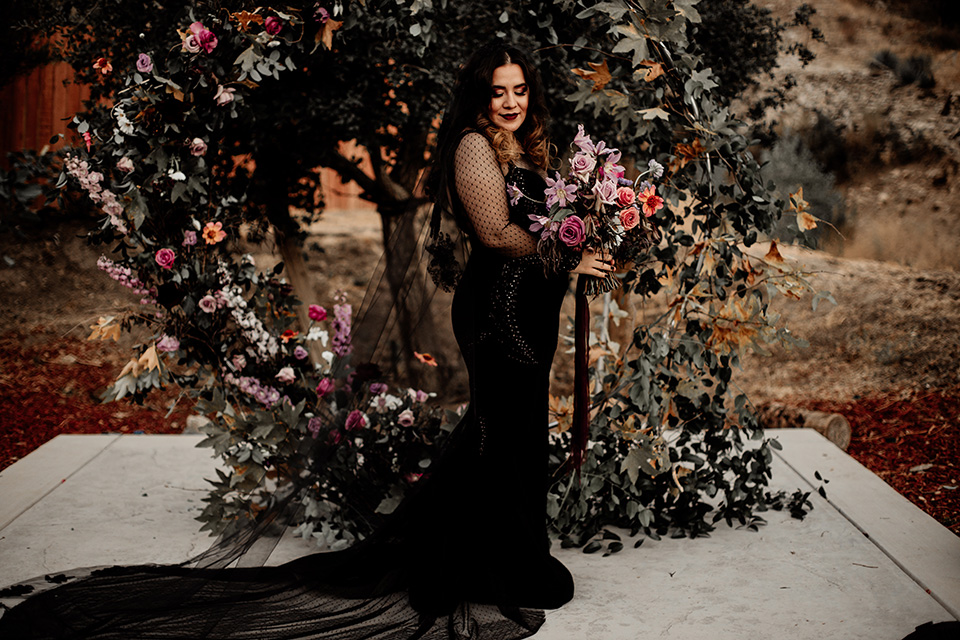  halloween inspired wedding with the groom in black velvet tuxedo bride in a black bridal gown with a pin dot overlay 