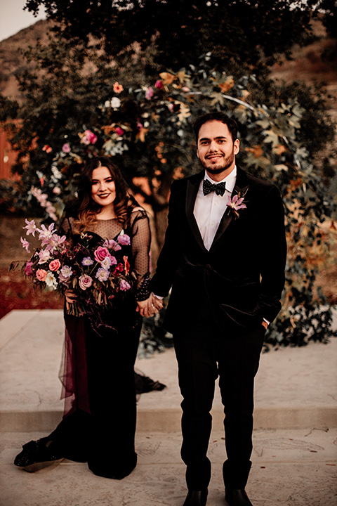  halloween inspired wedding with the groom in black velvet tuxedo bride in a black bridal gown with a pin dot overlay 