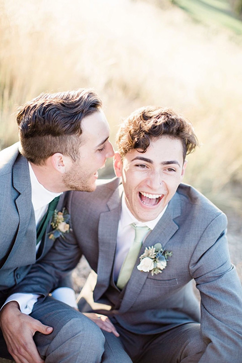  grooms in the same grey suit with 2 different color green ties 