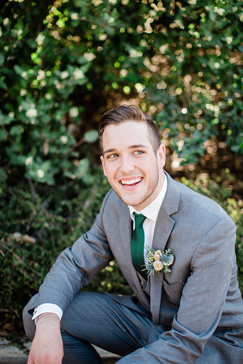  grooms in the same grey suit with 2 different color green ties 