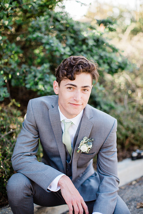  grooms in the same grey suit with 2 different color green ties 