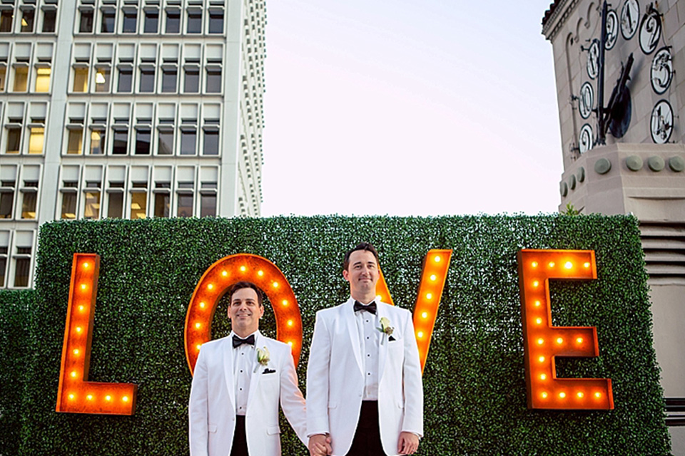 grooms in the same grey suit with 2 different color green ties