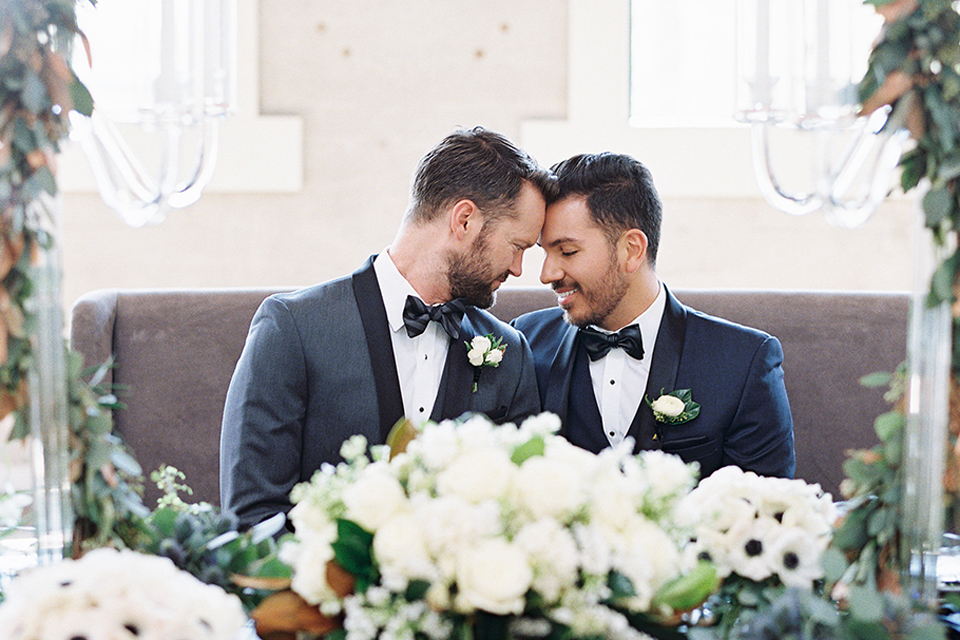 grooms in the same grey suit with 2 different color green ties