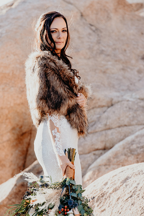  bride in a formfitting gown and a faux fur shawl