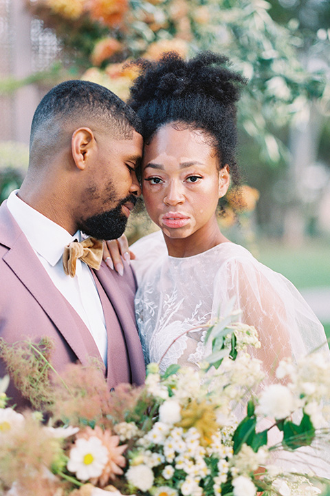  stunning chic pink and yellow wedding very french inspired, the bride is in a soft flowing gown with flutter sleeve and floral appliques and the groom in a rose pink suit with a gold velvet tuxedo  