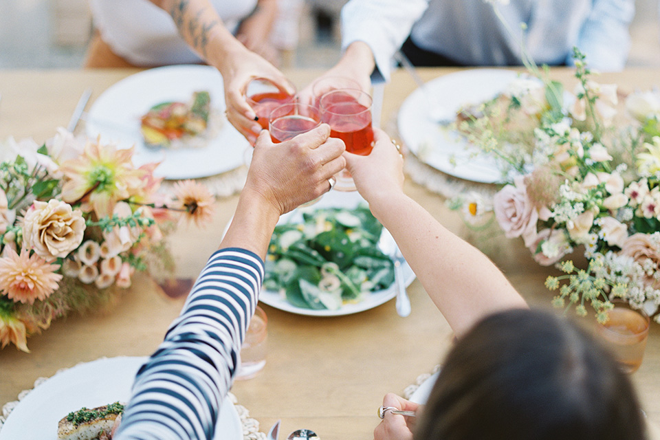  stunning chic pink and yellow wedding very french inspired, the bride is in a soft flowing gown with flutter sleeve and floral appliques and the groom in a rose pink suit with a gold velvet bow tie  