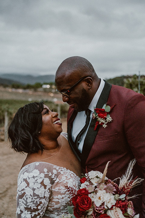  Letitia and Zach’s romantic vineyard burgundy + rose wedding – bride in her lace gown with long sleeves and the groom in a burgundy shawl lapel tuxedo