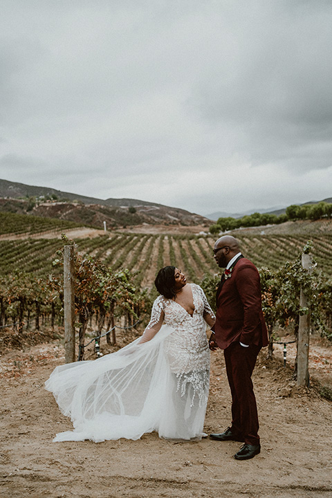  Letitia and Zach’s romantic vineyard burgundy + rose wedding – bride in her lace gown with long sleeves and the groom in a burgundy shawl lapel tuxedo 