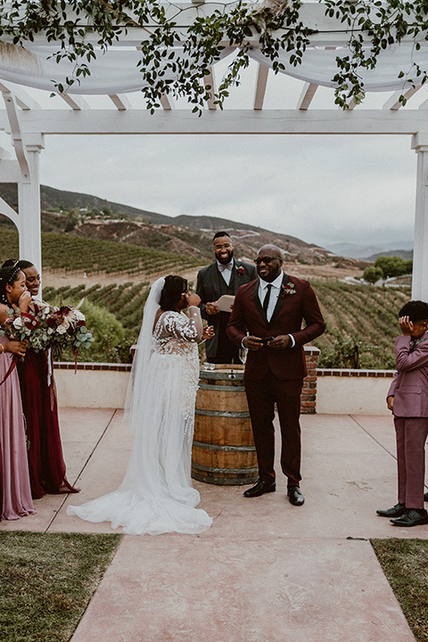  Letitia and Zach’s romantic vineyard burgundy + rose wedding – bride in her lace gown with long sleeves and the groom in a burgundy shawl lapel tuxedo