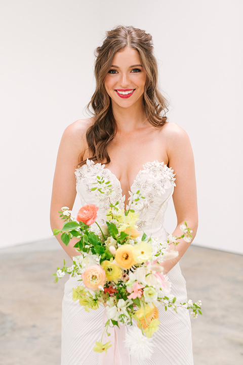  bride in a fashionable white jump suit with a strapless neckline and wide leg